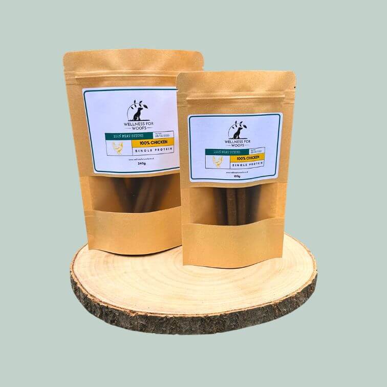 Pack of chicken meat sticks for dogs on a wooden plate