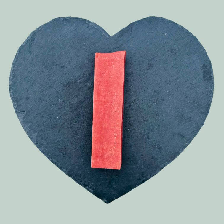 Extra large strawberry yak bar for dogs on a slate plate and jade green background