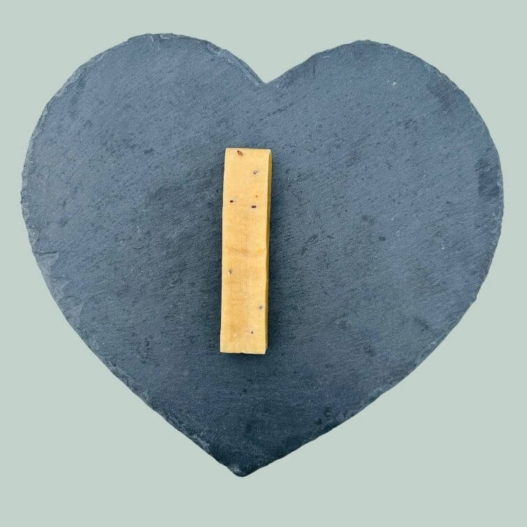 Medium flaxseed yak bars for dogs on a slate plate and jade green background