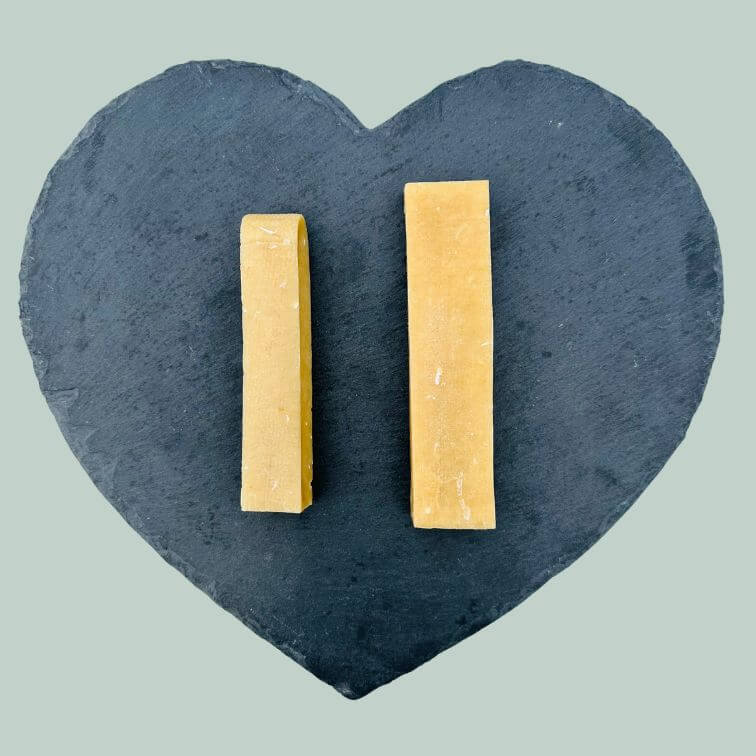 Range of coconut yak bar chews for dogs on a slate plate and jade green background