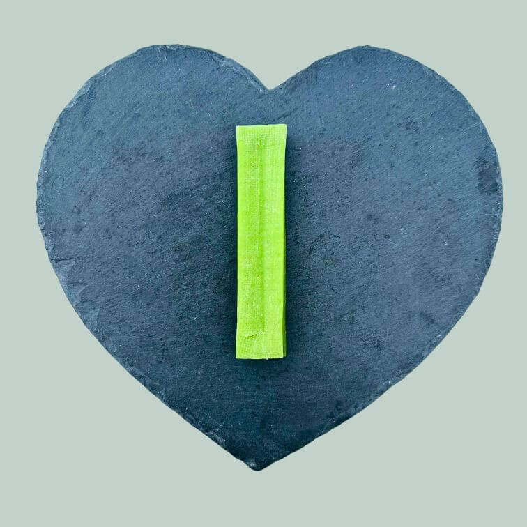 Large mint yak bar for dogs on a slate plate and jade green background