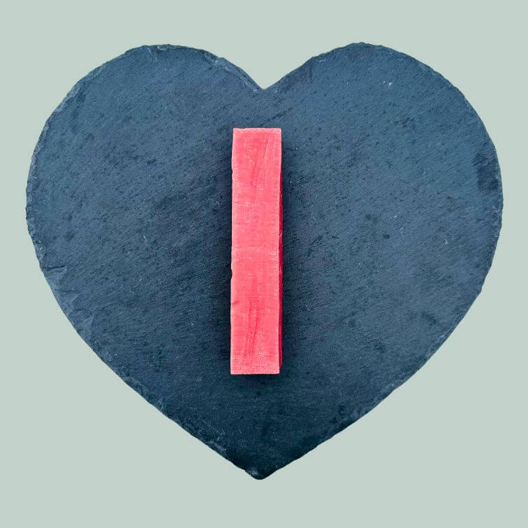 Large strawberry yak bar for dogs on a slate plate and jade green background