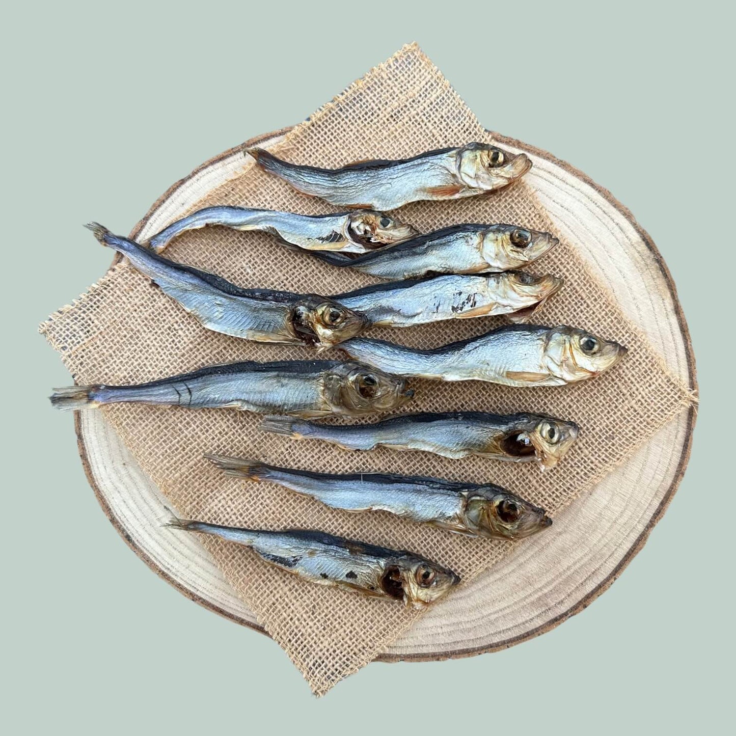 10 pack of dried herring dog treats on a wooden plate