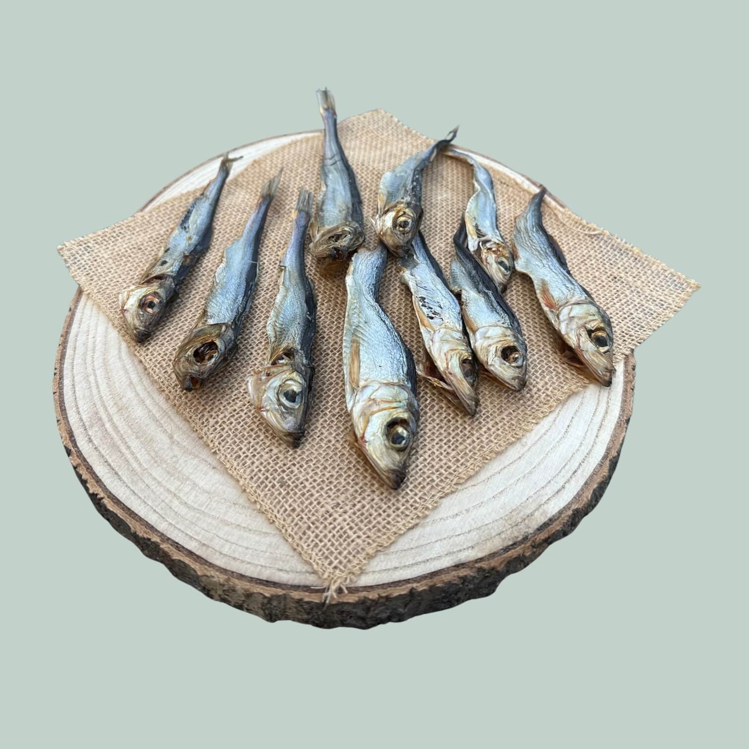 10 pack of dried herring treats for dogs on a wooden plate