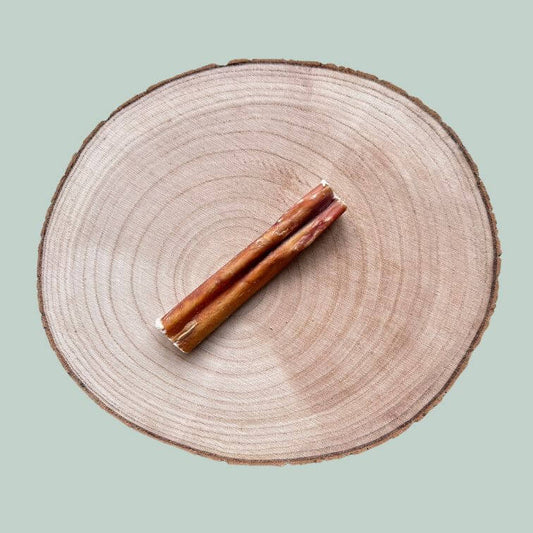 Single bull pizzle stick on a wooden slice plate