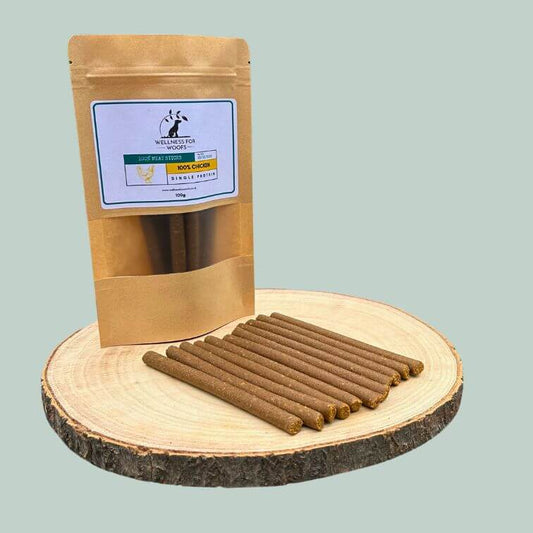 Pack of chicken meat sticks for dogs on a wooden plate
