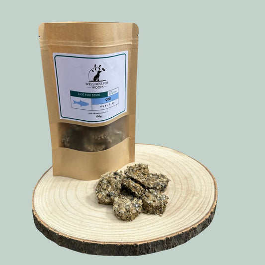 Pouch of cod disc treats for dogs next to a pile of treats on a wooden plate