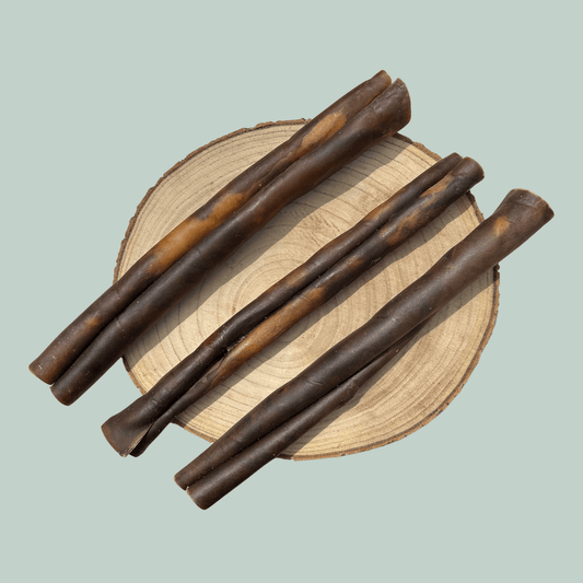 3 rolls of dried camel skin natural and healthy chews for dogs on a wood slice plate against a jade green background