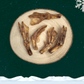 Five dried duck feet dog treats on wooden plate in front of a green starry sky backdrop with a white snowflake in the top right corner and a blanket of snow across the bottom.