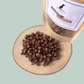 Pile of duck and cod training treats for dogs on a wooden plate with a eco-friendly pouch.