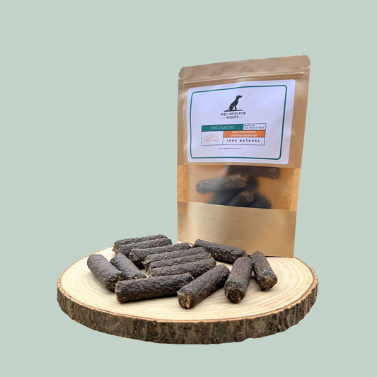 Dog treats on a wooden board with a branded packaging bag on a light green background