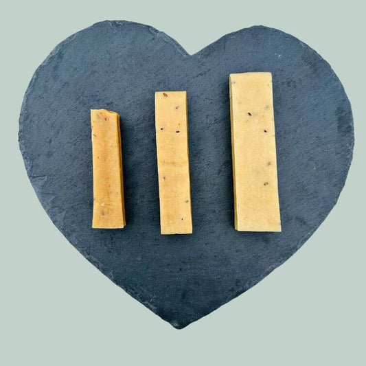 Full range of flaxseed yak bars for dogs on a slate plate and jade green background