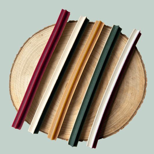 Set of colourful veggie dog treats on a wooden surface with a light grey background