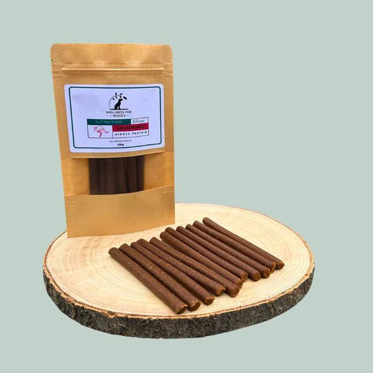 Pack of kangaroo meat sticks for dogs on a wooden plate