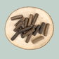 Single protein venison sausages for dogs on a wooden slice plate against a jade green background.