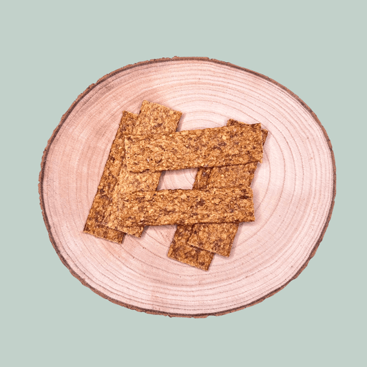 Pure meat strip dog treats on a wooden plate and jade green background