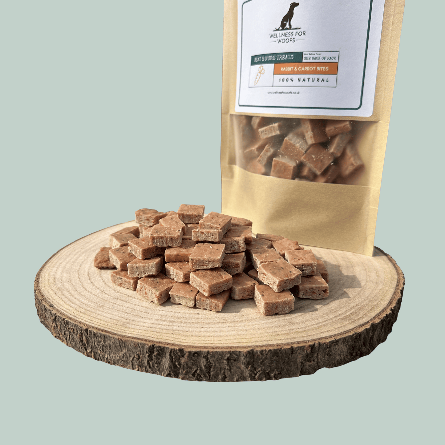 Rabbit and carrot dog training treats on a wooden platform with a branded packaging bag in the background