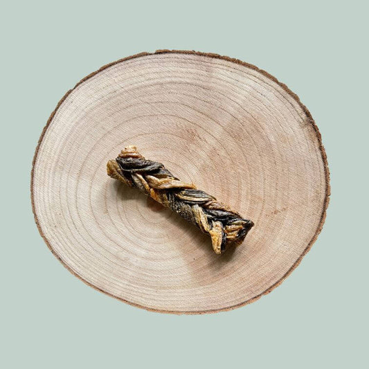Salmon skin braid dog chew on a wood plate and jade green background