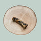 Salmon skin braid dog chew on a wood plate and jade green background