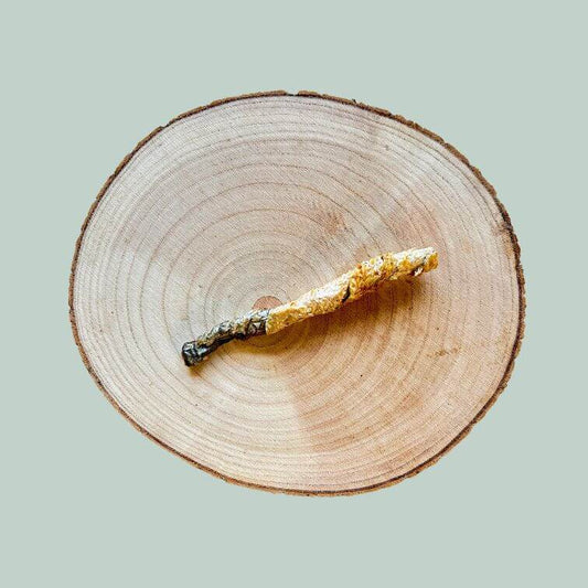 single salmon skin twist dog treat on a wooden plate