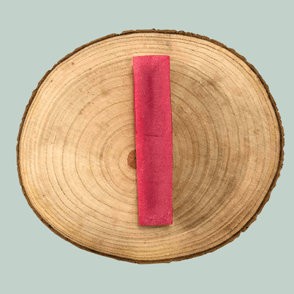 Wooden log with a pink strawberry yak bar dog chew on a light blue background