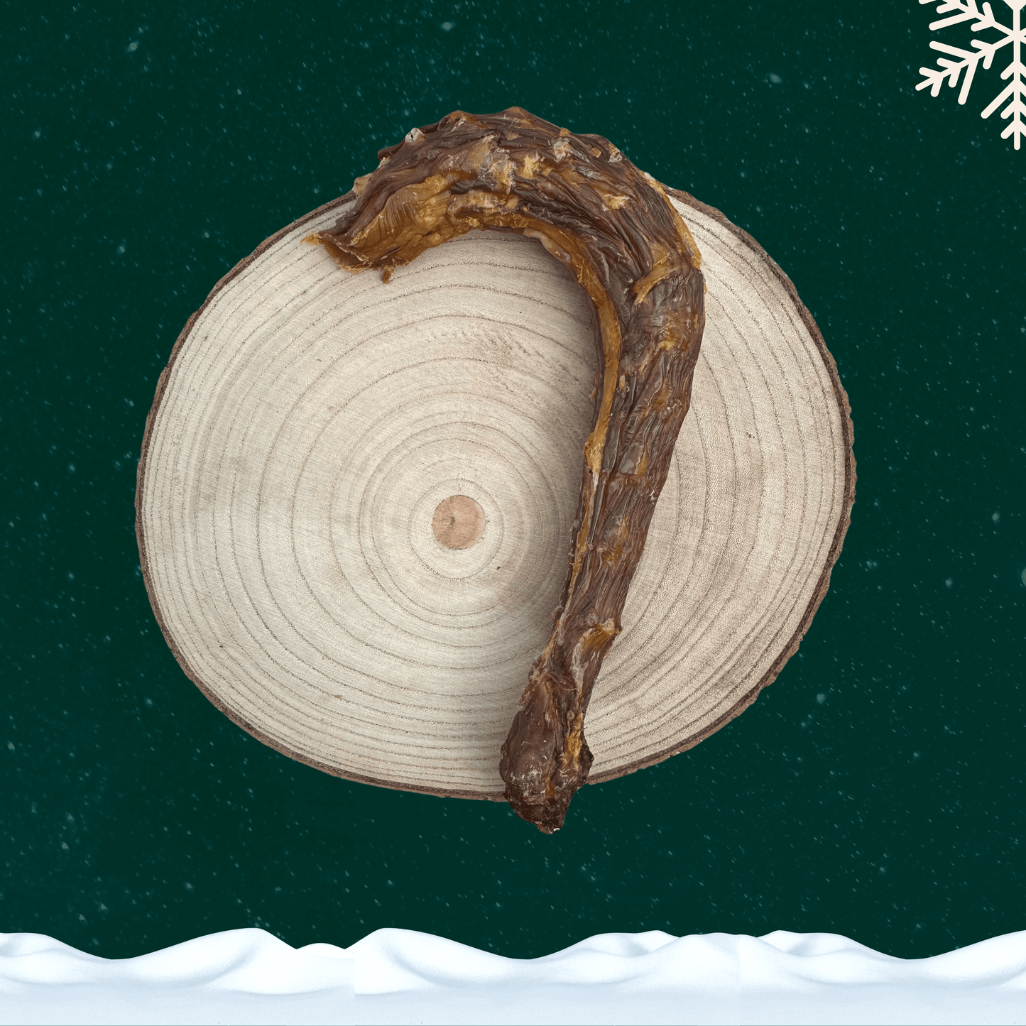 A dried turkey neck dog chew on a wooden plate against a dark green starry sky with a white snowflake in the corner and a blanket of snow across the bottom.