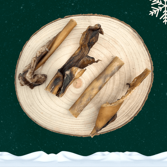 4 slices of venison skin chews for dogs on a wooden plate against a dark green starry sky background. There is a white snowflake in the top right corner and a blanket of snow across the bottom.